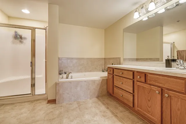 a spacious bathroom with a tub sink and mirror
