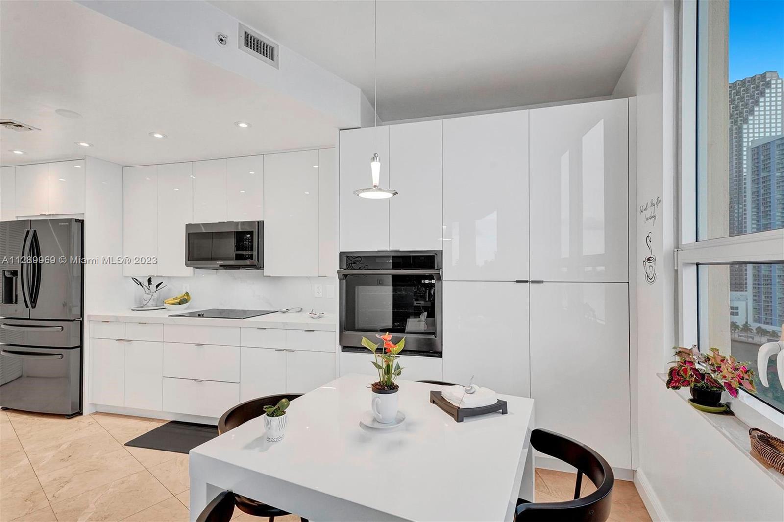 848 Brickell Key Drive, Unit 1602 Miami, FL 33131 - Photo 11 of 33 a kitchen with stainless steel appliances a microwave sink and refrigerator
