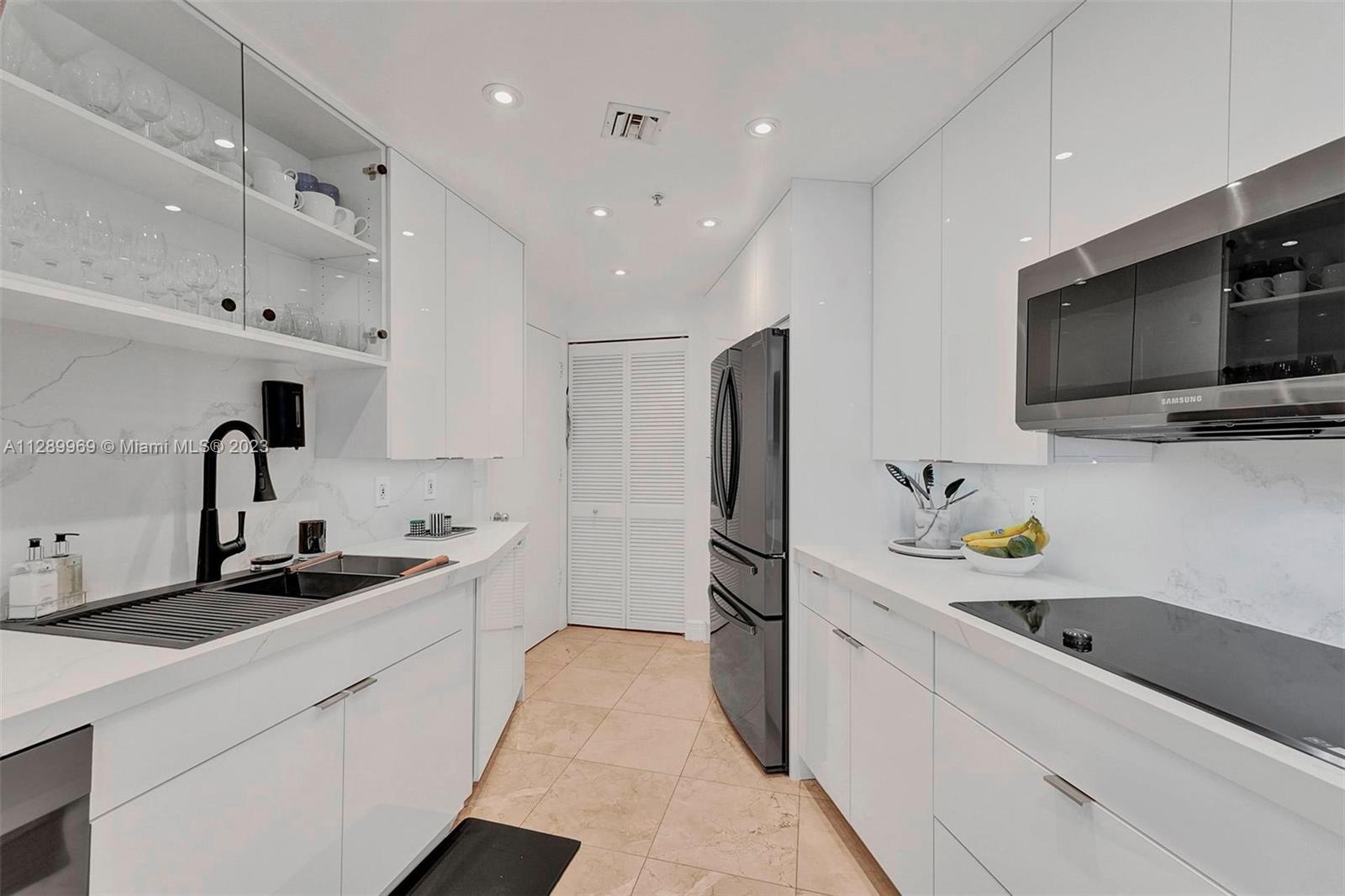 848 Brickell Key Drive, Unit 1602 Miami, FL 33131 - Photo 14 of 33 a kitchen with stainless steel appliances a sink a stove and a refrigerator
