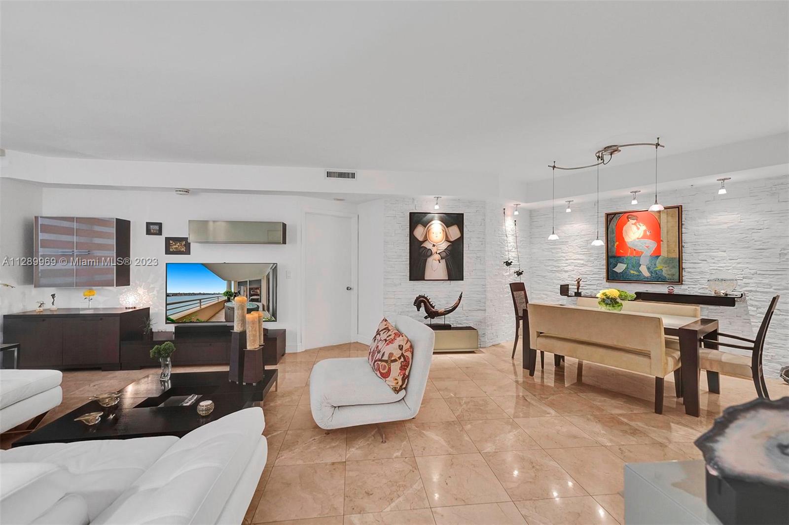 848 Brickell Key Drive, Unit 1602 Miami, FL 33131 - Photo 16 of 33 a living room with furniture and a flat screen tv