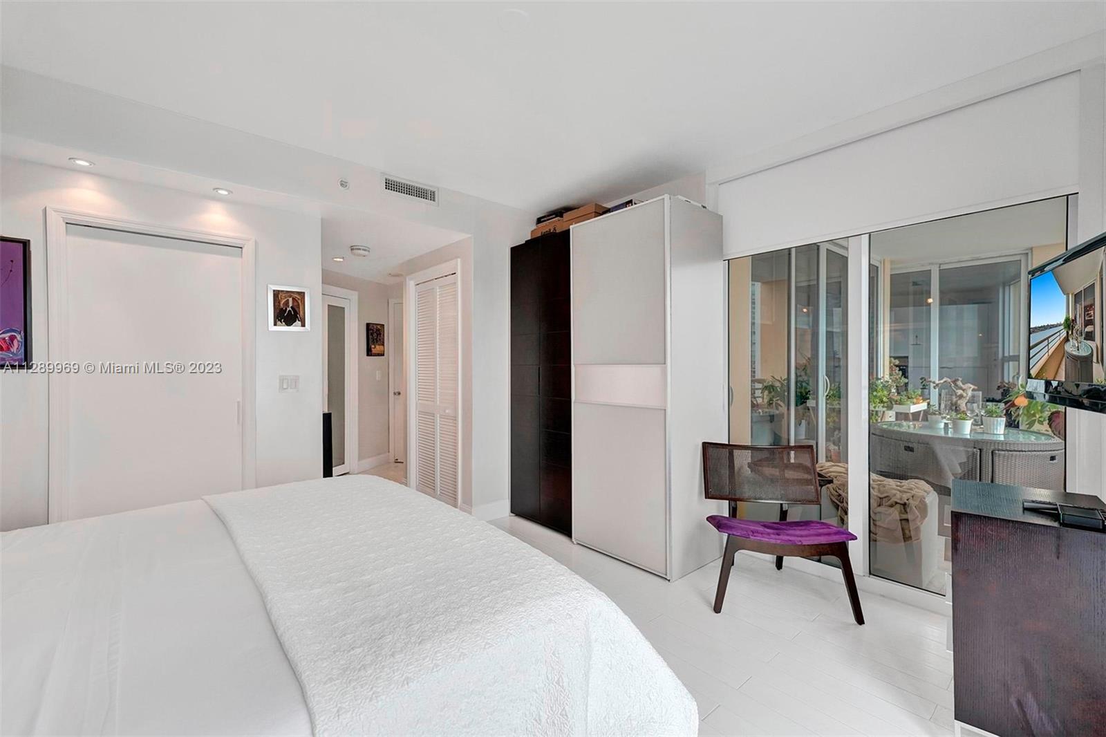 848 Brickell Key Drive, Unit 1602 Miami, FL 33131 - Photo 6 of 33 a bedroom with a bed a table and a potted plant