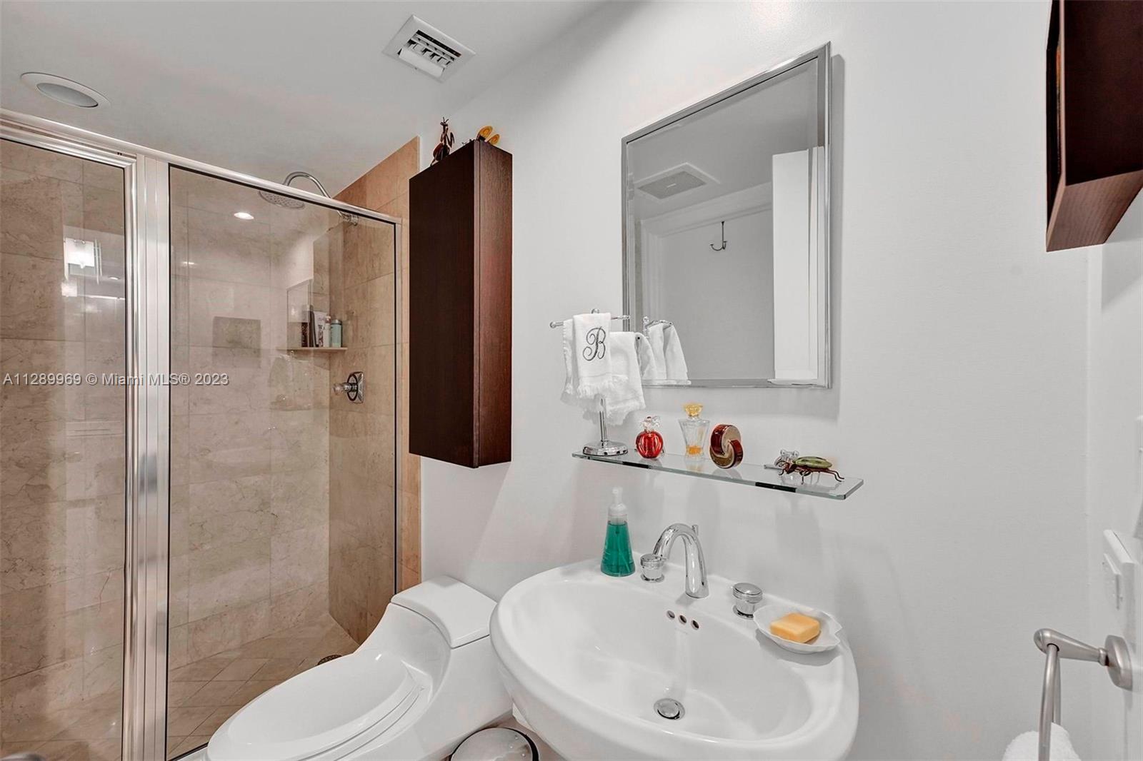 848 Brickell Key Drive, Unit 1602 Miami, FL 33131 - Photo 10 of 33 a bathroom with a sink and a mirror