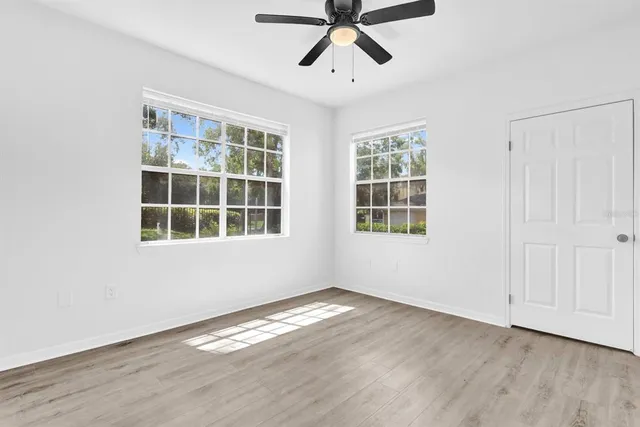 a view of empty room with wooden floor and window