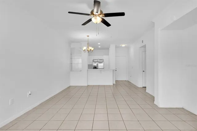 an empty room with an entryway and a chandelier fan