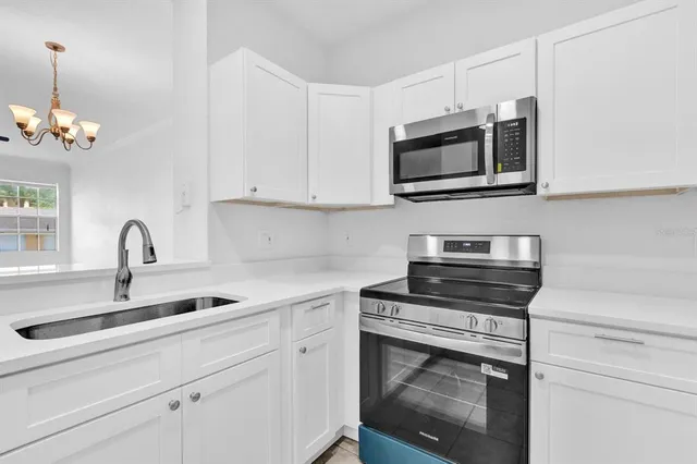 a kitchen with stainless steel appliances granite countertop a sink stove and microwave