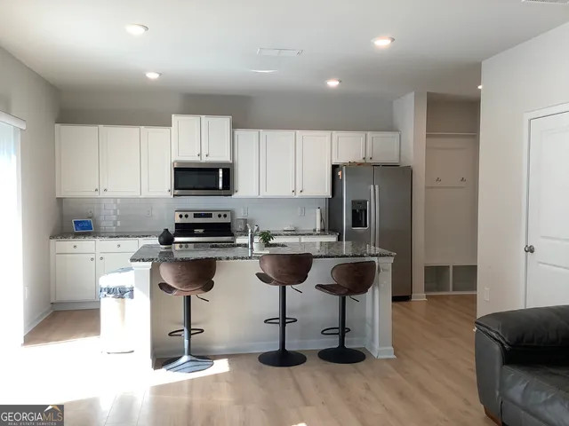 a kitchen with a refrigerator and a stove top oven