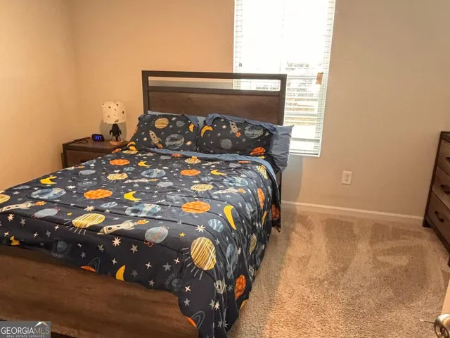 a bed sitting in a bedroom next to a window