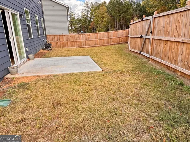 a view of backyard with wooden fence
