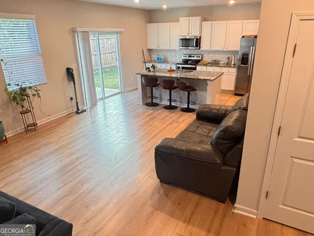 a living room with furniture and a wooden floor