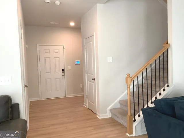 a view of a hallway with wooden floor and staircase
