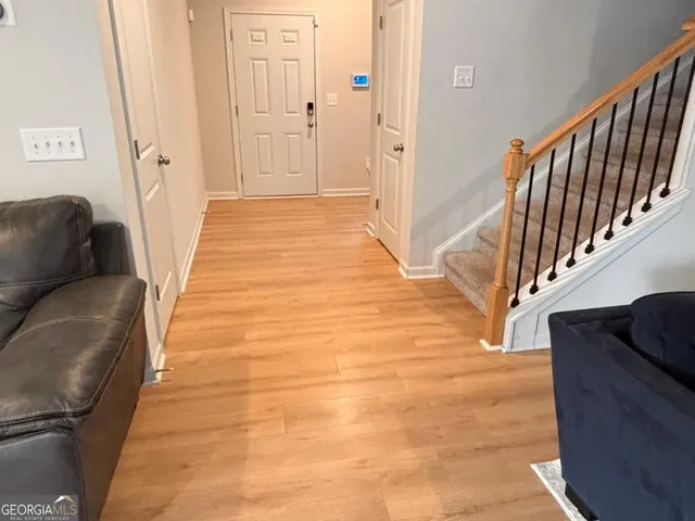 a view of a hallway with wooden floor and staircase