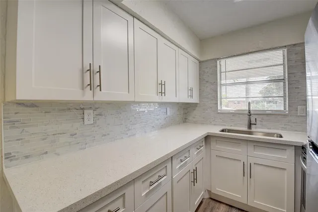 a kitchen with a sink cabinets and window