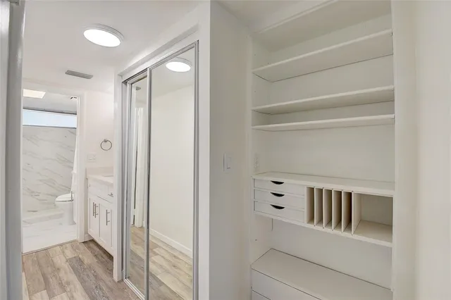 a view of a hallway with closet and bathroom