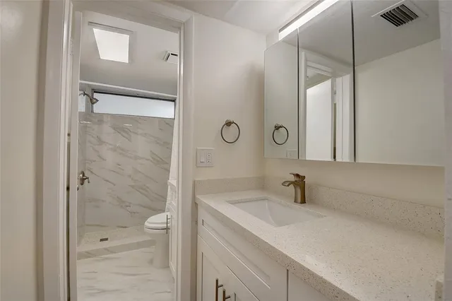 a bathroom with a shower sink and mirror