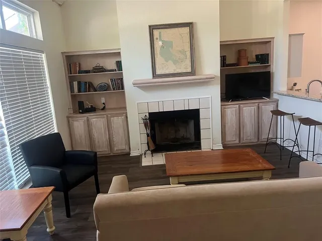 a living room with furniture a flat screen tv and a fireplace