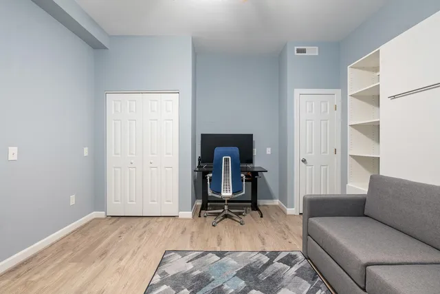 a living room with a couch and a dresser with wooden floor