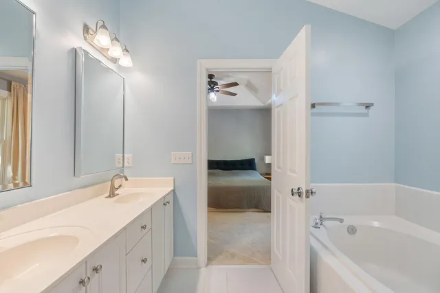 a bathroom with a tub a sink and mirror