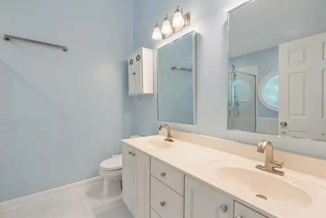 a bathroom with a toilet sink and mirror