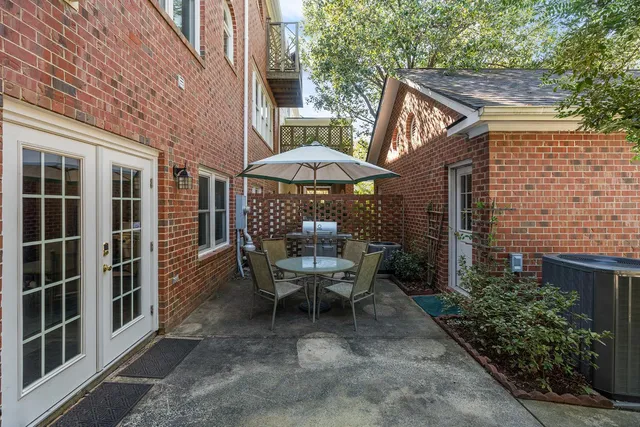 a view of a patio with a table and chairs under an umbrella