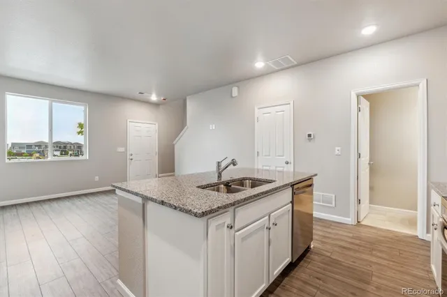 a kitchen with a sink cabinets and wooden floor