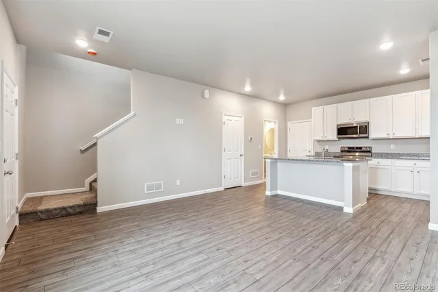 a view of kitchen with granite countertop cabinets and refrigerator