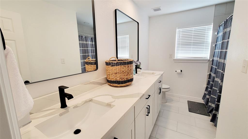 1447 West Lingleville Road Stephenville, TX 76401 - Photo 10 of 12 Bathroom featuring double vanity and marble look tile flooring
