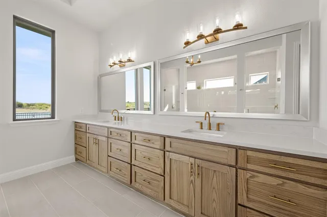 a spacious bathroom with double sink and a mirror