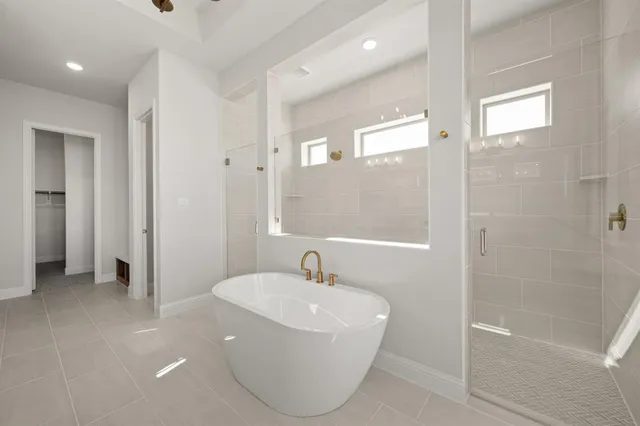 a bathroom with a white bath tub sitting next to a white sink