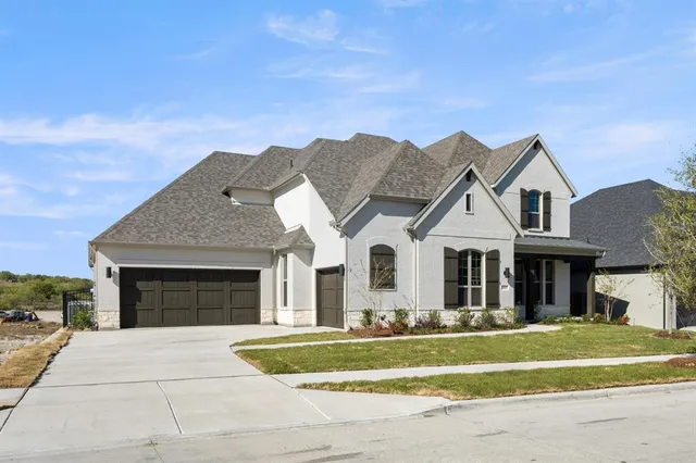 a front view of a house with a garden and yard
