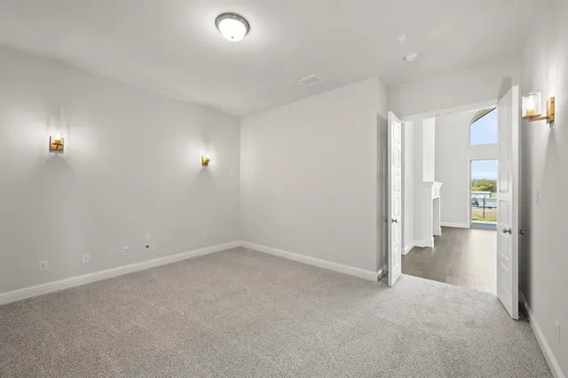 an empty room with closet and windows