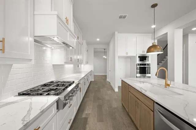 a kitchen with stainless steel appliances granite countertop a sink stove and refrigerator