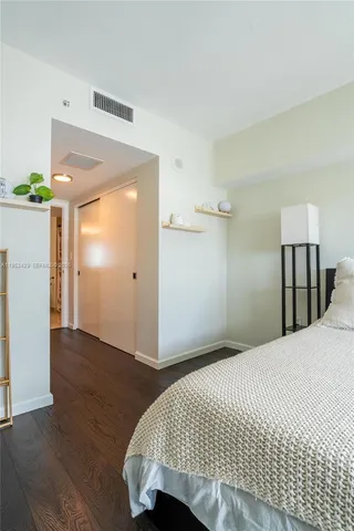 a bedroom with a bed and a refrigerator