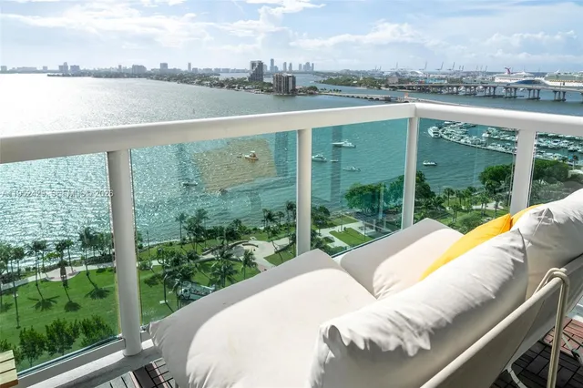 a view of a lake from a balcony with an outdoor seating