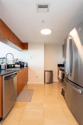 a kitchen with stainless steel appliances granite countertop a sink and a refrigerator