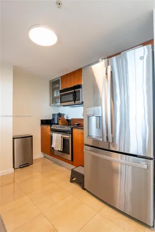 a kitchen with stainless steel appliances granite countertop a refrigerator sink and microwave