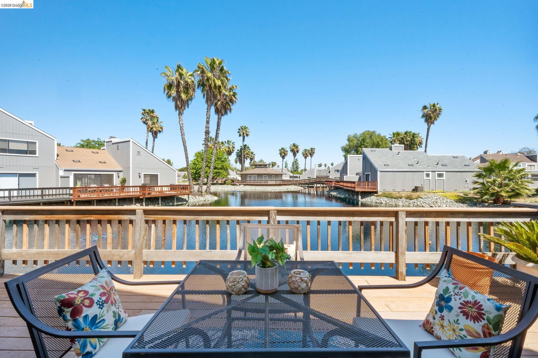 2051 Sand Point Road Discovery Bay, CA 94505 - Photo 2 of 47 Expansive wood-finish deck with a wood-slat railing overlooking a serene waterway