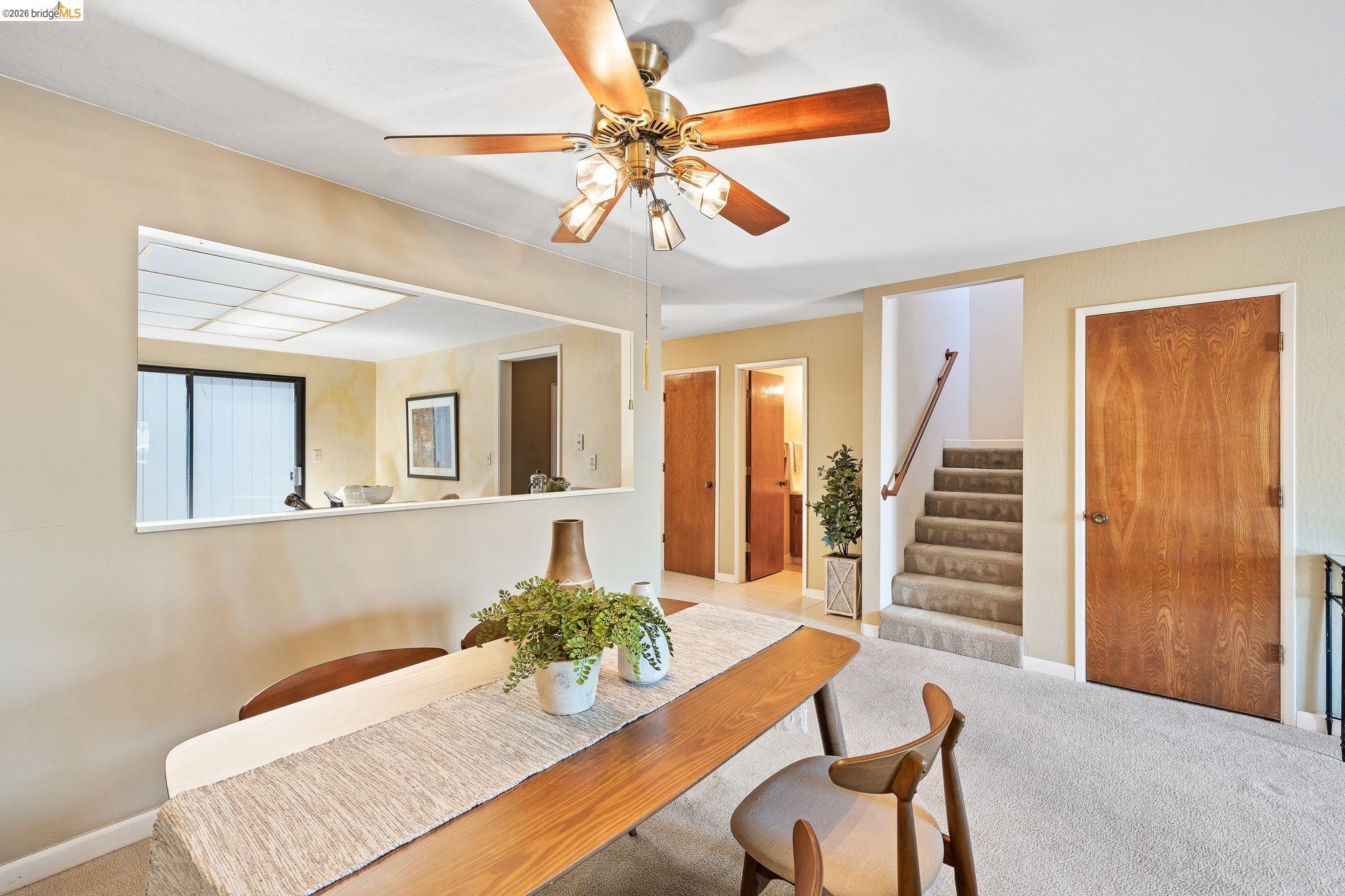 2051 Sand Point Road Discovery Bay, CA 94505 - Photo 21 of 47 Dining area featuring a ceiling fan with light fixture, carpeted flooring, and a pass-through window opening