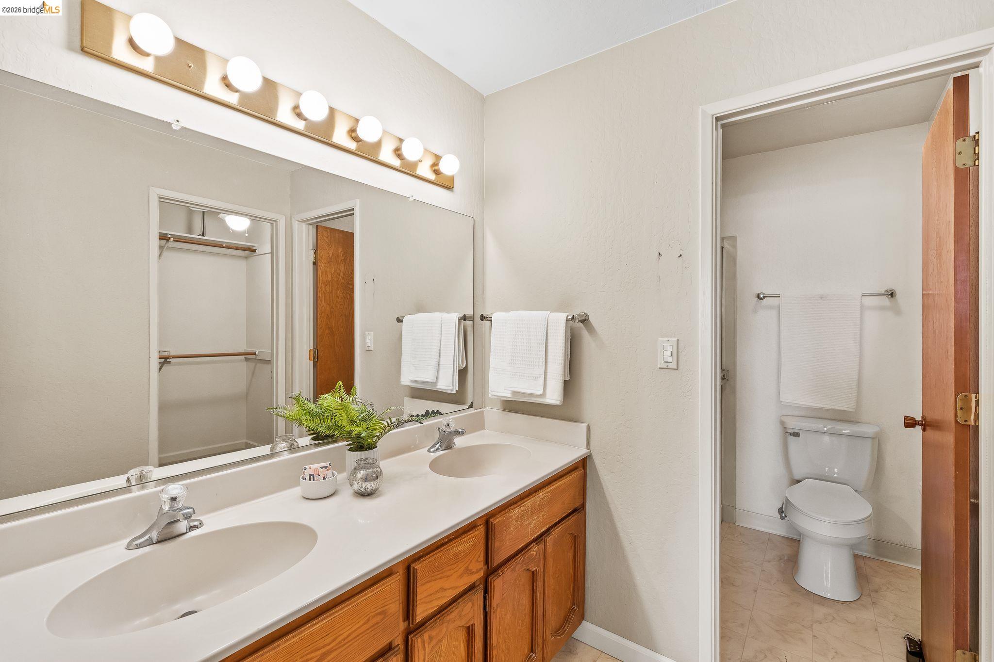 2051 Sand Point Road Discovery Bay, CA 94505 - Photo 29 of 47 Bathroom featuring a double vanity with light wood-finish cabinetry, a large integrated countertop, and two oval undermount sinks