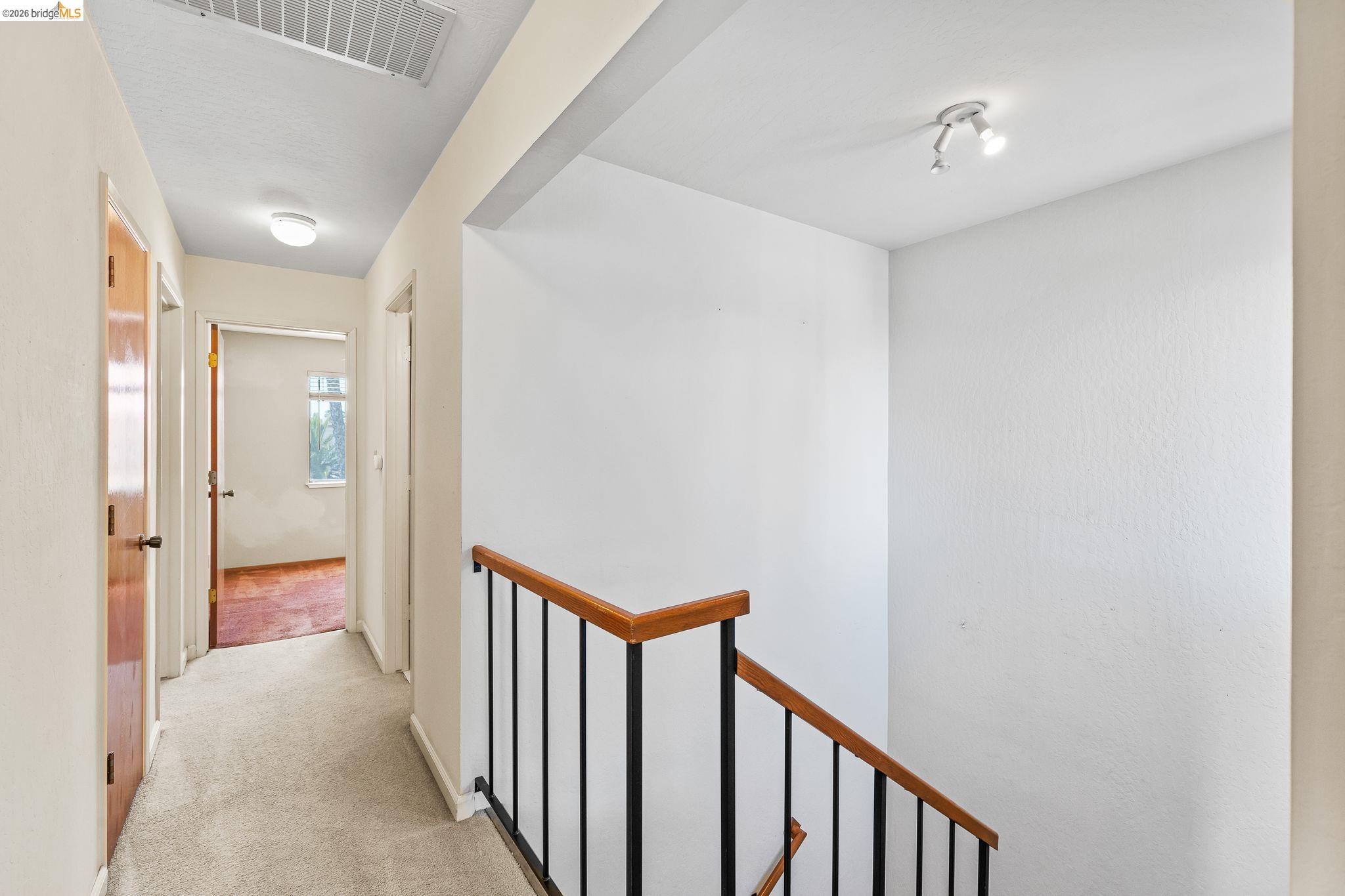 2051 Sand Point Road Discovery Bay, CA 94505 - Photo 31 of 47 Carpeted hallway featuring a flush-mount ceiling light and wood-finish doors