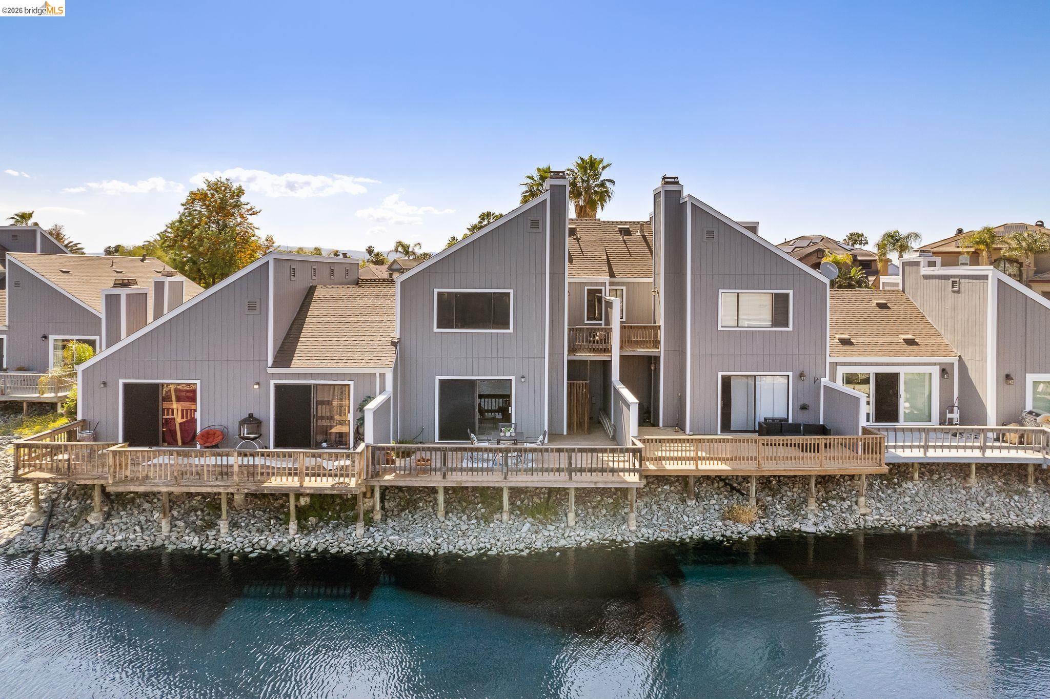 2051 Sand Point Road Discovery Bay, CA 94505 - Photo 37 of 47 Waterfront property featuring multiple private decks, sliding glass doors, and a contemporary architectural design with gabled roofs