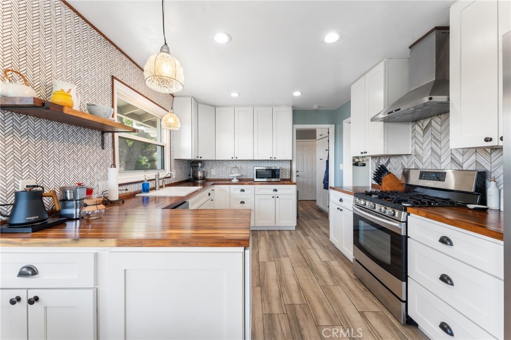 4380 Miramonte Place Riverside, CA 92501 - Photo 18 of 73 a kitchen with stainless steel appliances granite countertop a stove a sink dishwasher and a refrigerator with wooden floor