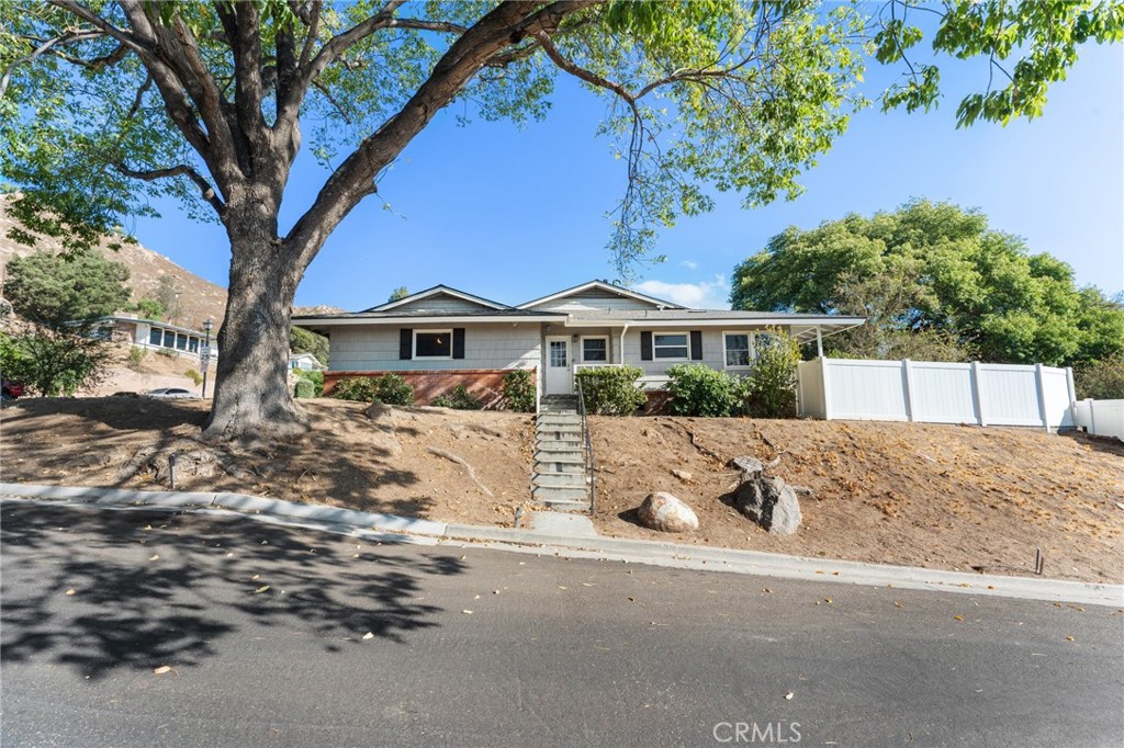 4380 Miramonte Place Riverside, CA 92501 - Photo 60 of 73 a view of a white house with a large tree and wooden fence