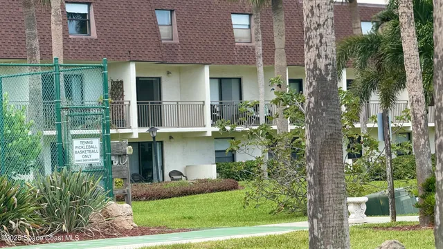 a view of a brick house with a yard and plants