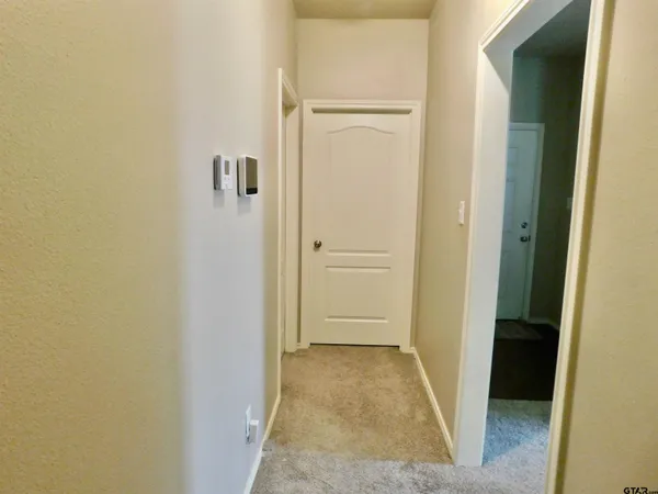 a view of a hallway with closet and wooden floor