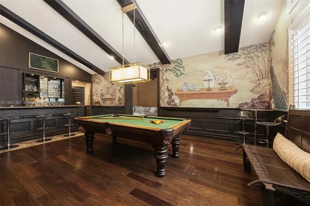 a room with furniture pool table wooden floor and windows