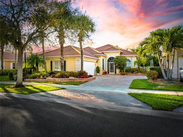 a front view of a house with a yard and palm trees