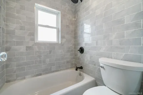 a white toilet sitting next to a bath tub