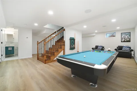 a room with furniture pool table flat screen tv and windows