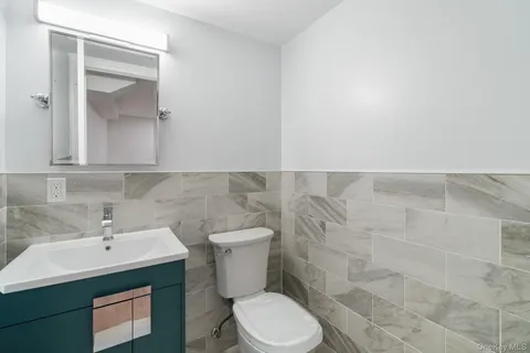 a bathroom with a toilet sink and mirror