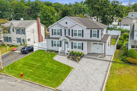 a front view of a residential houses with yard and green space